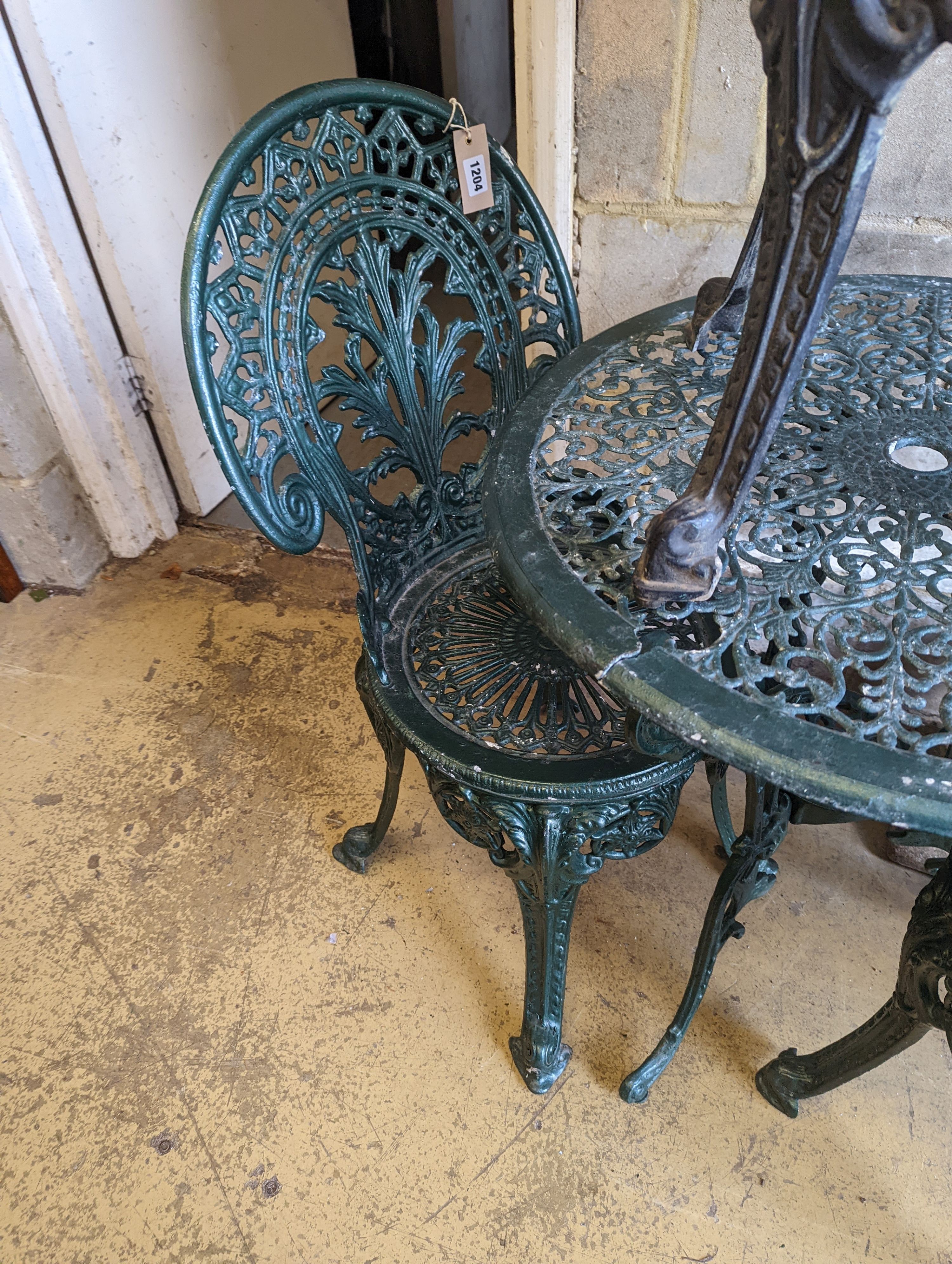 A circular painted aluminium garden table, diameter 65cm, together with three chairs